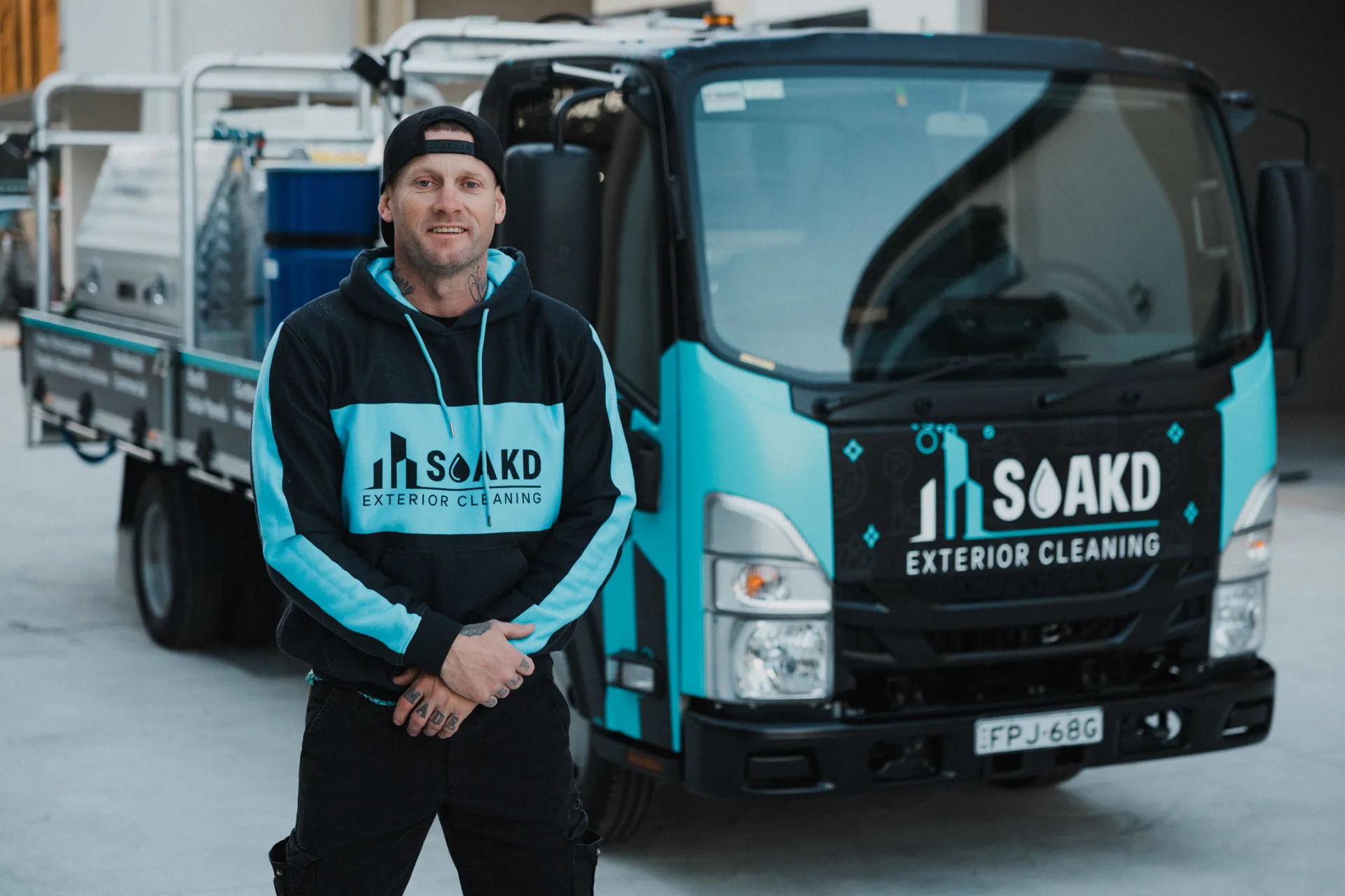 Daniel Fenton, founder of SOAKD Exterior Cleaning, in front of the branded SOAKD truck