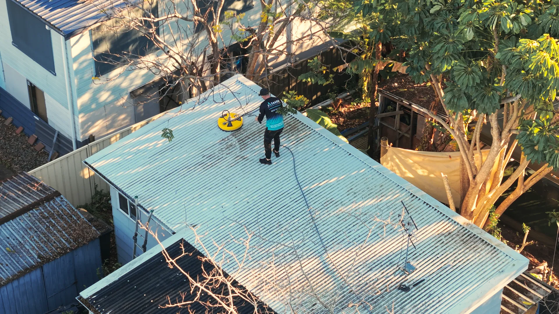 SOAKD operator softwashing a residential tile roof